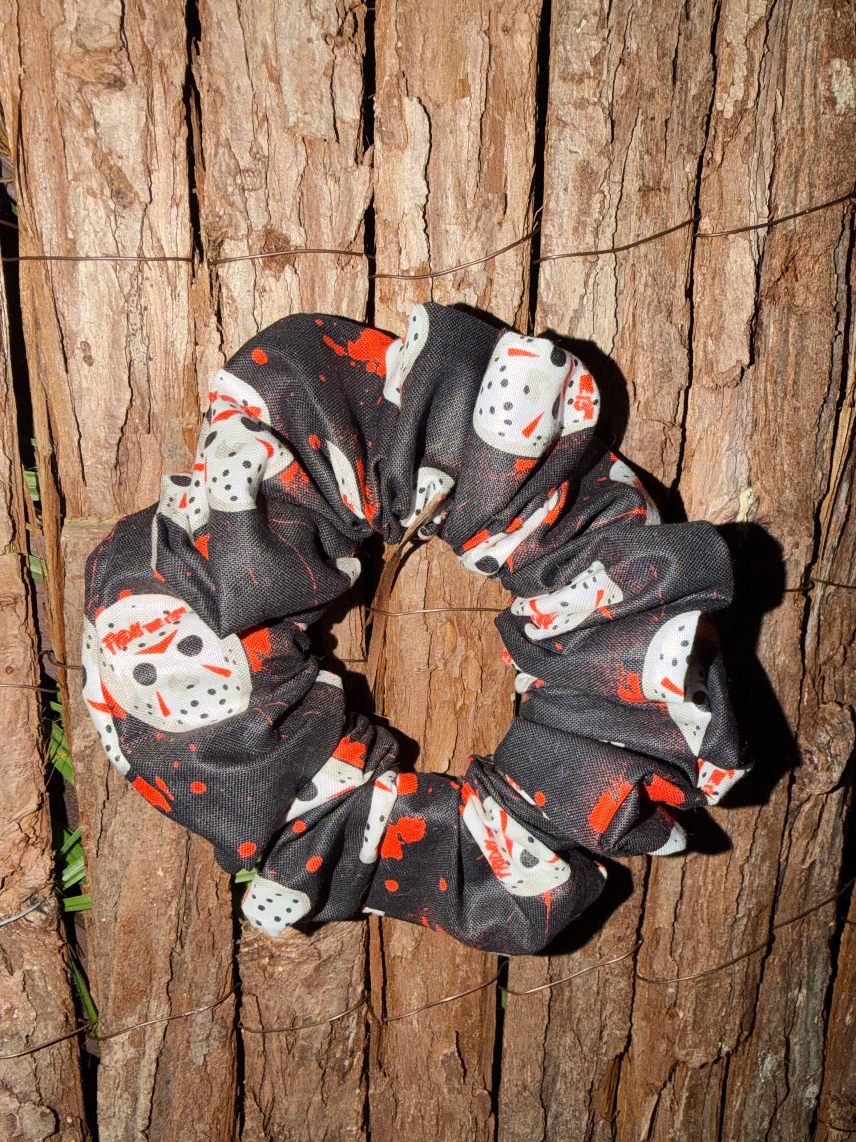 Black scrunchie with red and white pattern on wooden surface